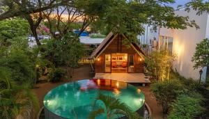 a house with a pond in the middle of a yard at Maadest in Phnom Penh