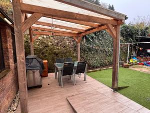 een houten pergola met een tafel en stoelen bij Ferienwohnung Daviana in Beckingen