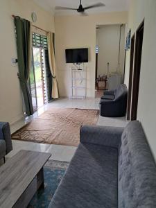 a living room with a couch and a tv at Homestay Kubang Kerian, Kota Bharu in Kota Bharu