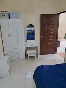 a bedroom with a bed and a desk and a door at Homestay Kubang Kerian, Kota Bharu in Kota Bharu