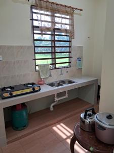 a kitchen with a sink and a window at Homestay Kubang Kerian, Kota Bharu in Kota Bharu