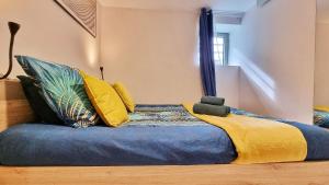 een bed met kleurrijke kussens in een kamer bij Gîte Renaud et Lauren - Terrace - Horbourg-Wihr in Horbourg