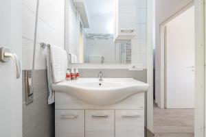 een badkamer met een wastafel en een spiegel bij Sole e Mare Buggerru - Appartamento in Buggerru +18 foto's