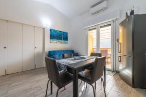 een keuken en eetkamer met een tafel en een koelkast bij Sole e Mare Buggerru - Appartamento in Buggerru