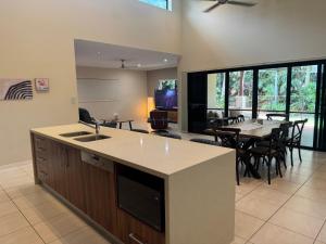 Una cocina y una sala con una mesa y un comedor. en Entire 4 bedroom home in Palm Cove, en Palm Cove