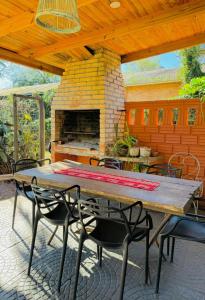 einen Tisch und Stühle auf einer Terrasse mit Kamin in der Unterkunft Tuchita House en Cataratas con piscina compartida parrilla, cochera in Puerto Iguazú