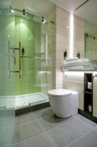 Un baño con inodoro y ducha de cristal. en hub London - King's Cross, en Londres