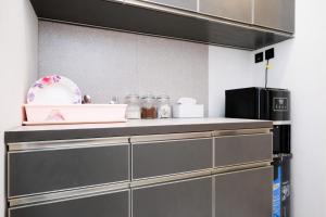 a kitchen with gray cabinets and a counter top at Sans Vibes Hotel Damai Yogyakarta in Kejayan