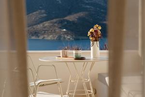 a table with a vase of flowers on top of it at PhosAlos Apartments in Aegiali