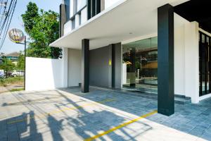 a facade of a building with a sign on the sidewalk at Sans Vibes Hotel Damai Yogyakarta in Kejayan
