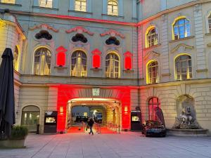een groot gebouw met een rode streep erop bij Hotel Deutsches Theater Landwehrstraße in München