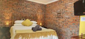 Un dormitorio con una pared de ladrillo y una cama. en LyonsDen 1, en Worcester