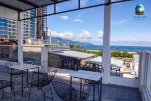 een terras met tafels en stoelen en uitzicht op de oceaan bij Coastal Nest - Steps to Sand in Da Nang