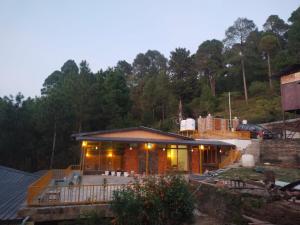 a house with a porch and a deck at Pinaka Devbhumi Homestay in Mukteshwar