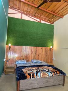 a bedroom with a bed with a green wall at Pinaka Devbhumi Homestay in Mukteshwar