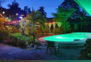 プエルト・プリンセサにあるLa Casa d Aitor Poolside Apartments with Wood Fired Pizza near city centerの夜間の庭のスイミングプール