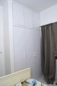 a white bedroom with white cabinets and a bed at WHITE FLAT ALMADIES in Dakar