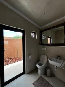 a bathroom with a toilet and a sink and a mirror at Rietfontein 1888 in De Aar