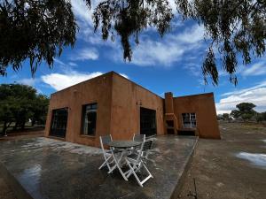 a table and chairs in front of a building at Rietfontein 1888 in De Aar
