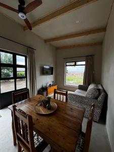 a dining room with a wooden table and a couch at Rietfontein 1888 in De Aar +8 photos