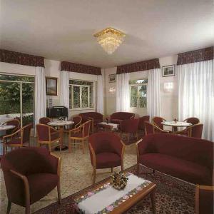 a restaurant with tables and chairs and a chandelier at Residence Miralago Rooms & Apartments in Manerba del Garda
