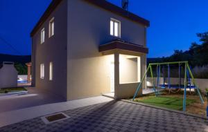 een huis met een speeltuin ervoor bij Villa Ivan by Villas Guide in Primorski Dolac