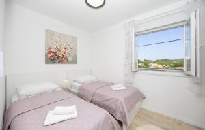 twee bedden in een witte kamer met een raam bij Villa Ivan by Villas Guide in Primorski Dolac +27 foto's