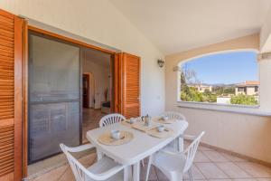 a white table and chairs in a room with a window at Le Dimore di Budoni in Budoni