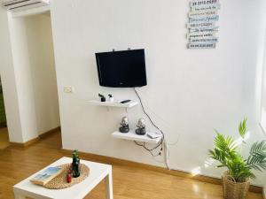 ein Wohnzimmer mit Fernseher und Tisch in der Unterkunft Apartamento San Miguel by At Home Costa del Sol in Nerja