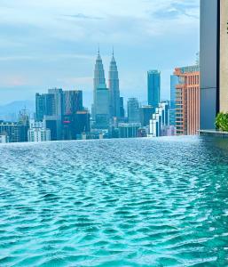 a view of a city skyline from the water at Lucentia Residence by Infinity swimming pool,lalaport KL in Kuala Lumpur