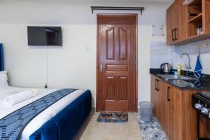 een slaapkamer met een bed, een wastafel en een deur bij Cyan Studio with free WI-FI in Nanyuki
