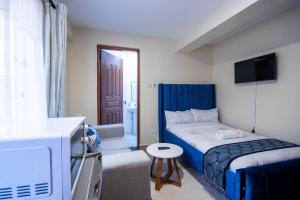 een kleine slaapkamer met een bed en een televisie bij Cyan Studio with free WI-FI in Nanyuki +9 foto's
