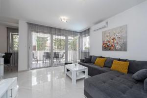 a living room with a couch and a table at Villa Mel Mari luxury apartments with pool in Novalja