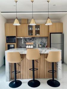 eine Küche mit zwei Barhockern vor einer Theke in der Unterkunft Villa Bun Blessi in Pesanggaran