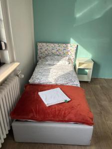 Un pequeño dormitorio con una cama con una manta roja. en Amazing entire Apartment, U79&S1, Messe, Airport, Hbf, 6-Seen-Platte, en Duisburg