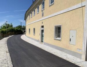 an empty road next to a building at Yellow House Apartments - Top 3 in Steyr