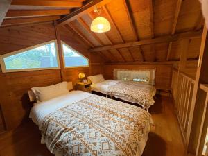 a bedroom with two beds in a cabin at beau lac biwako annex in Takashima