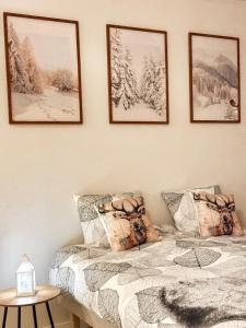 a bedroom with a bed and four pictures on the wall at Warm Wooden Home in Rovaniemi in Rovaniemi +8 photos