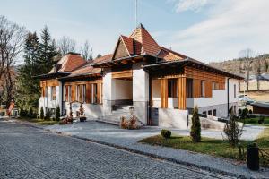 una casa con tetto in legno su una strada di Villa Bellini Borszék a Borsec