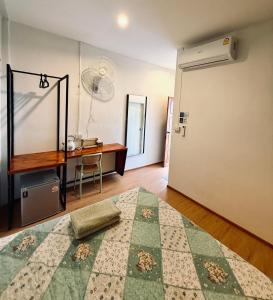 a room with a bed and a desk and a door at Happiness Hostel Private room in Phra Ae beach