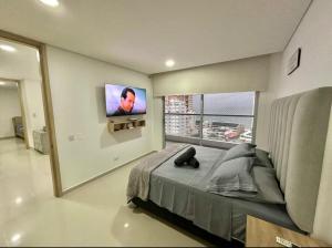 a bedroom with a bed and a tv on the wall at Tu apartamento en la playa piso 10 in Cartagena de Indias +79 photos