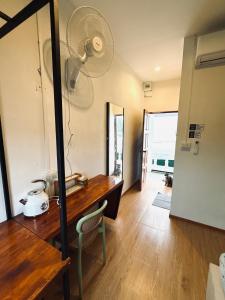 a living room with a desk and a fan at Happiness Hostel Private room in Phra Ae beach +19 photos