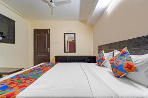 Un dormitorio con una gran cama blanca con almohadas de colores. en Via AB Top, en Coimbatore