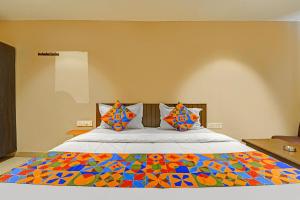 Un dormitorio con una cama con un edredón colorido. en Via AB Top, en Coimbatore