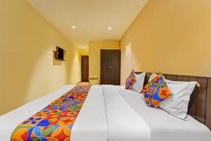 Un dormitorio con una cama grande con almohadas de colores. en Via AB Top, en Coimbatore