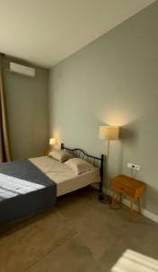 a bedroom with a bed and a side table at Villa Saguramo in Saguramo +2 photos