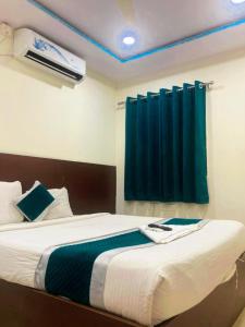 a bedroom with a bed with a blue curtain at At Home Hotel Darbar in Hyderabad