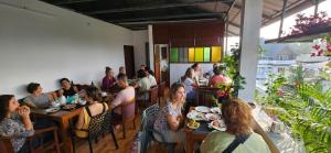 a group of people sitting at tables in a restaurant at Goodkarma Inn in Cochin