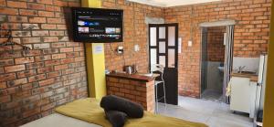 Habitación con TV en una pared de ladrillo en LyonsDen 1, en Worcester