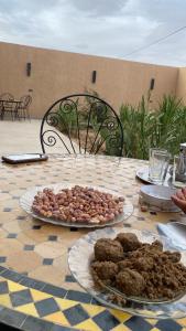 a table with plates of food on top at Sunny Place apartments in Merzouga